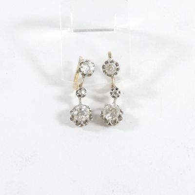 gros plan d'une paire de boucles d'oreilles sur une surface blanche