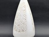 un vase blanc orné d'un motif sur fond noir