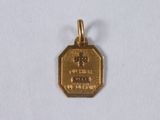 a small gold medal with a cross on it