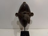sculpture of a fish on a black stand on a white surface