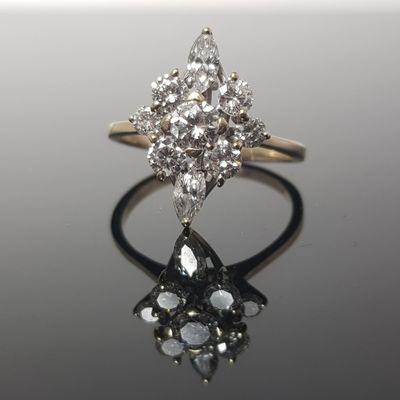 une image d'une bague en diamant sur une surface réfléchissante