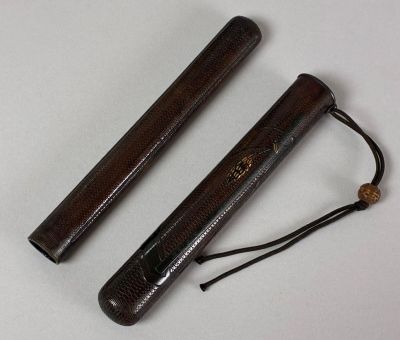 pair of wooden sticks on a white surface with a black cord