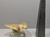 une statue représentant un oiseau perché sur un socle, à côté d'une sculpture représentant un oiseau