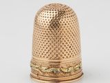 un dé à coudre en or 18 carats orné d'un motif