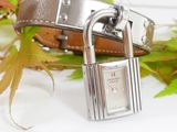 a silver watch with a padlock on a brown leather strap