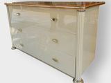 an image of a white chest of drawers with a gold top