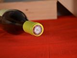a bottle of wine sitting on a table with a red cloth