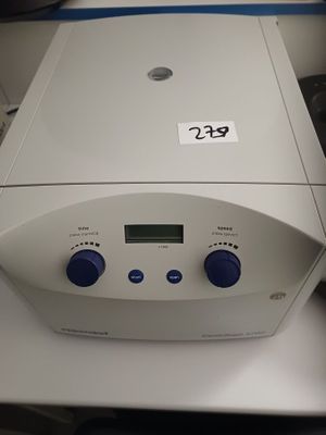une machine blanche avec des boutons bleus, posée sur une table