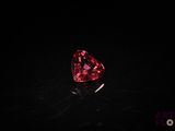 a heart shaped pink diamond on a black surface