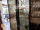 a glass door refrigerator in the middle of a kitchen