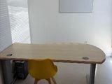 a desk with a yellow chair and a white board on the wall