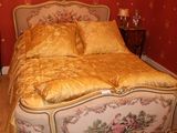 un lit avec une couette dorée et des oreillers dans une chambre