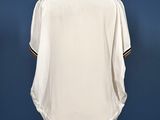 a white shirt on a mannequin stand against a blue wall