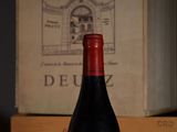 a bottle of wine sitting on a table next to a box of wine