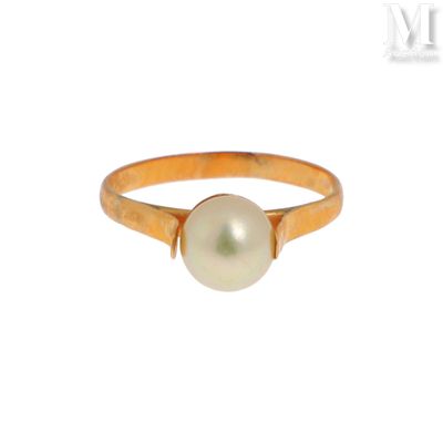 un gros plan d'une bague en perle sur fond blanc