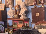 de nombreux tableaux accrochés aux murs d'une pièce où l'on trouve de nombreuses œuvres d'art accrochées aux murs