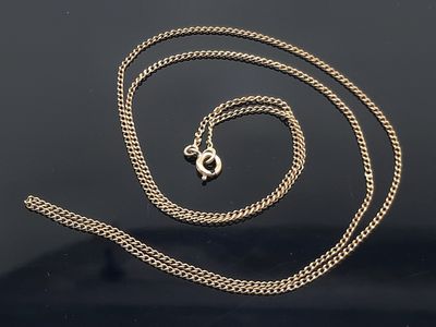 un gros plan d'une chaîne en argent sur une surface noire