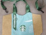 a bag with a starbucks logo on it sitting on a couch