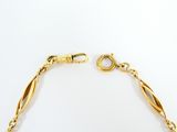 an image of a gold bracelet with a twisted link