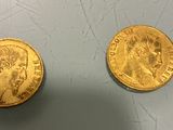 two pieces of gold coins sitting next to each other on a table