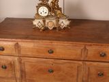 a wooden dresser with a clock on top of it