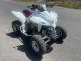 a white four wheeler atv parked on the side of the road