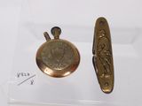 a small gold pocket watch and a small pocket watch on display