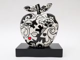 black and white apple sculpture on black base on white background