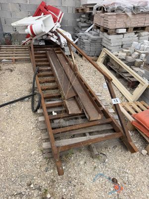 a pile of wood sitting on the ground next to a pile of bricks