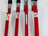 trois outils rouges posés sur une surface blanche