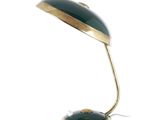 une image représentant une lampe de bureau verte sur fond blanc
