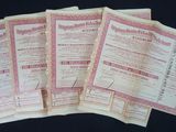 five old paper certificates are stacked on top of each other