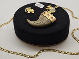 une boîte noire entourée d'une chaîne en or et un collier orné d'un éléphant