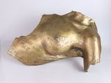 a gold sculpture of a woman ' s head on a white surface