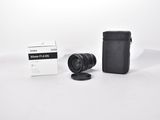 the camera is sitting next to the box of the lens