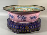 un bol rose et bleu posé sur un socle bleu