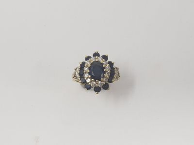 a close up of a diamond and sapphire ring on a white surface