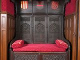 un lit en bois avec un coussin rouge dans une chambre