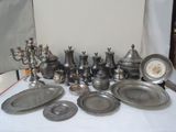 beaucoup d'objets en étain sur une table recouverte d'une nappe blanche