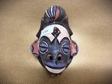 a picture of a ceramic mask on a gold background