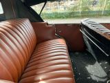 a brown leather couch sitting in the back of a car