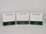 three boxes of lacoste products sitting on a white surface