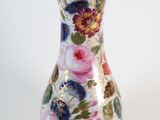 a vase with a floral design on it on a white surface