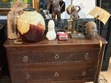 une commode sur laquelle sont posés de nombreux objets