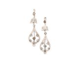 une paire de boucles d'oreilles en argent serties de diamants sur fond blanc
