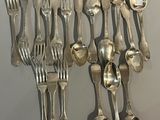 de nombreuses cuillères et fourchettes en argent accrochées au mur