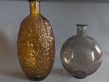 two glass vases sitting next to each other on a table