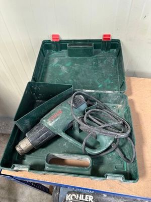 a green box with a drill and a cord in it
