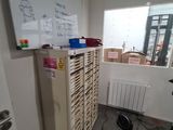 a refrigerator in the corner of a room with a whiteboard on the wall