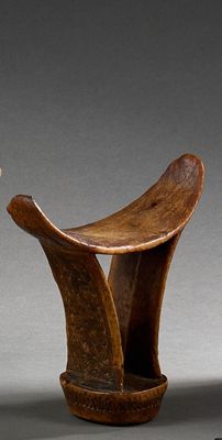 paire de tabourets en bois sculpté aux pieds courbés, posés sur un socle gris